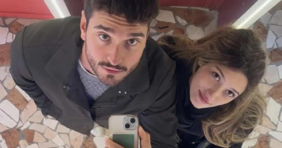 O imagine surprinde un cuplu tânăr realizând un selfie în oglindă, dintr-o perspectivă de sus, într-un spațiu cu pardoseală din mozaic.