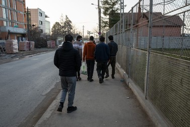 Câțiva migranți ies de la Centrul Regional de Proceduri şi Cazare a Solicitanților de Azil – Timișoara. Centrele sunt în regim deschis, dar dacă lipsesc mai mult de trei zile, pierd dreptul de a sta acolo.