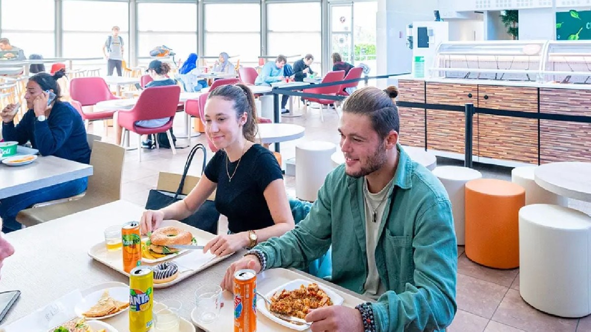 Studenți la masă, la o cantină universitară