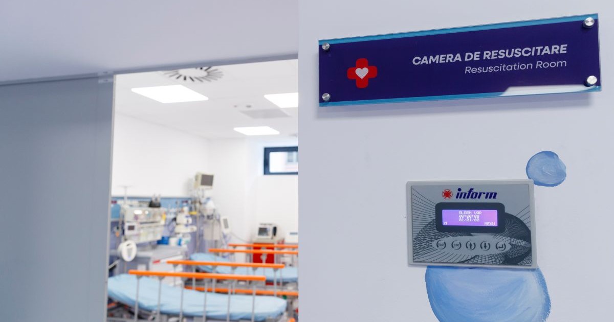 Intrarea în camera de resuscitare de la Spitalul de Copii Louis Țurcanu din Timișoara, cu ușa deschisă, pereții albi și o placă pe care scrie camera de resuscitare