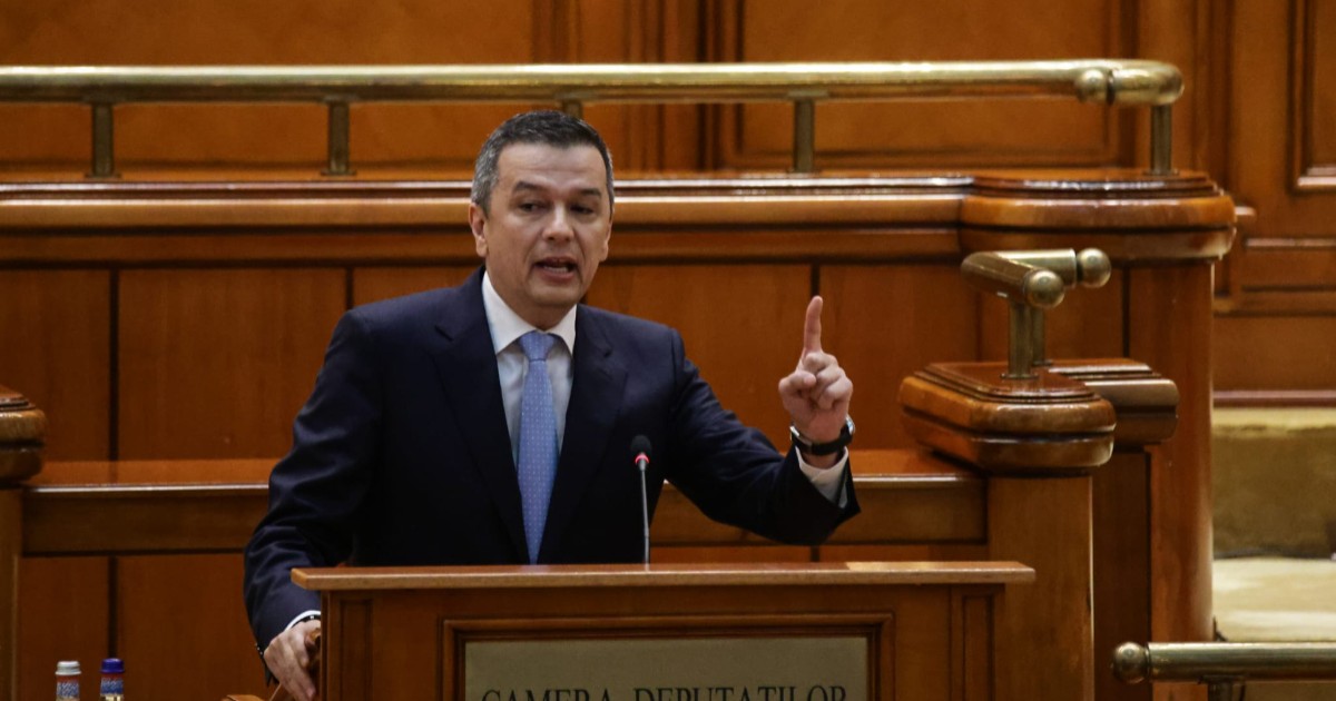 Sorin Grind îmbrăcat la costum, cu o cravată albastră, la pupitrul din Camera Deputaților, în timpul discursului pe care îl susține în Parlament