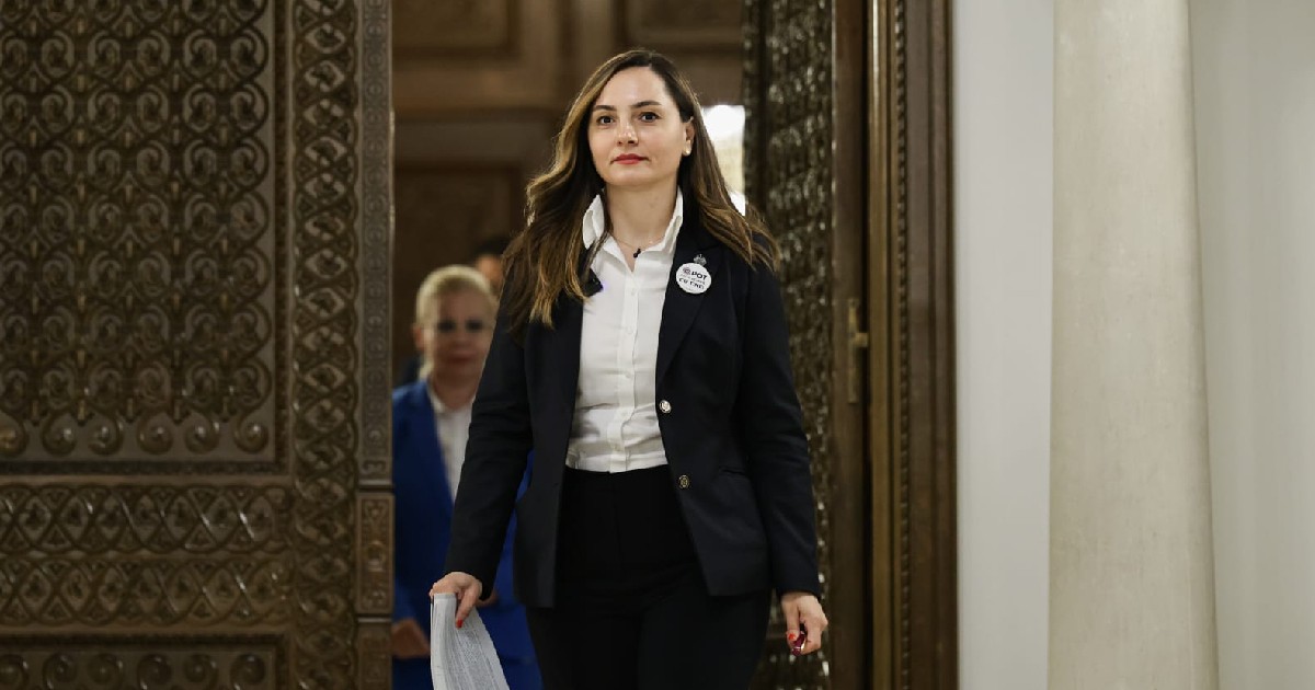Anamaria Gavrilă poartă un costum business negru cu cămașă albă clasică și sacou