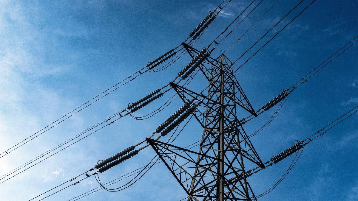 În imagine e un stâlp de electricitate uriaș, pe fundalul unui cer albastru