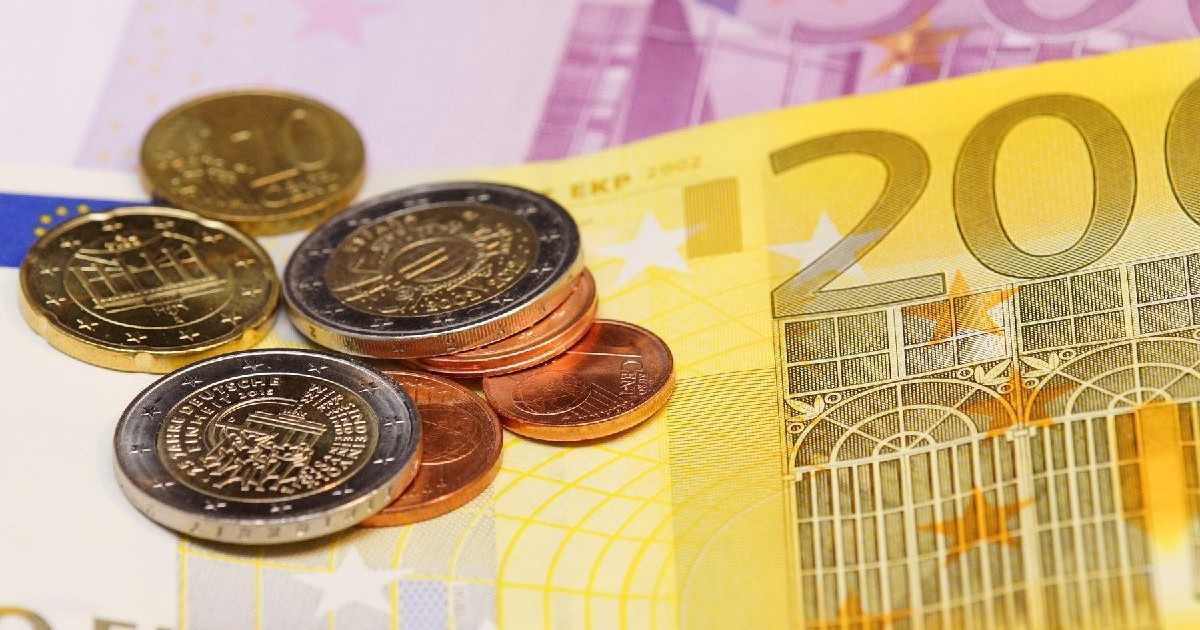 Imaginea prezintă un detaliu cu diverse bancnote euro, inclusiv una de 200 și una de 500, peste care sunt așezate câteva monede de diferite valori nominale.
