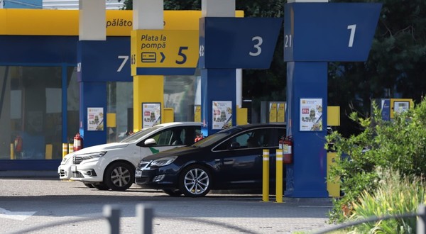 Mai multe autoturisme sunt staționate la pompele de alimentare ale unei stații de carburant.