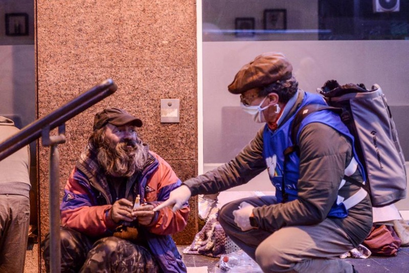 Românul, primind ajutor de la voluntarii asociației Sant'Egidio. Foto: santedigio.org