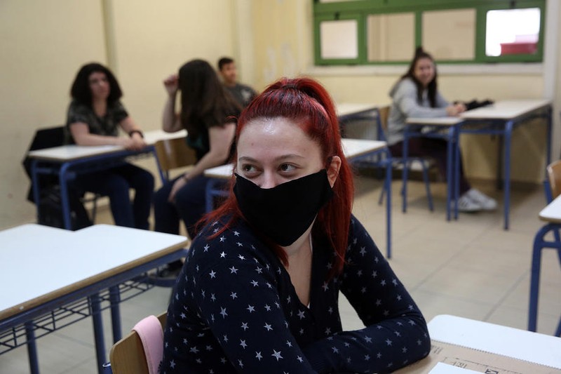 Elevii din clasa a a XII-a de la un liceu din Atena au revenit în clase. Cursurile fuseseră suspendate de pe 12 martie. Foto: EPA