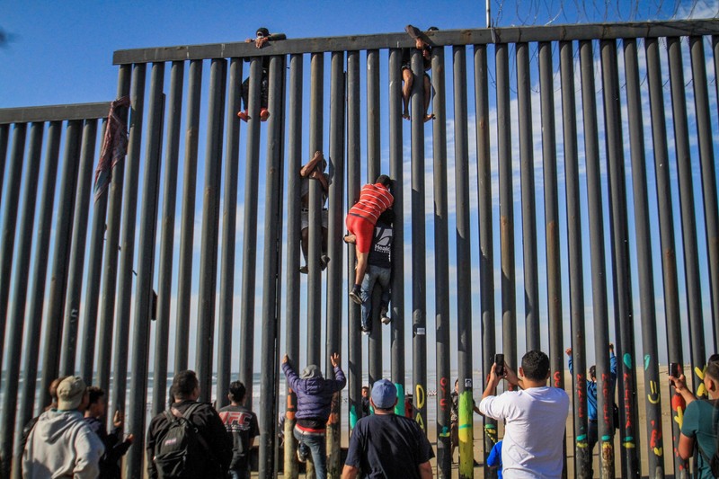 Immigrants jumping over the fence in the Tijuana area, in the Mexican state of Baja California. The spot is a favorite with Romanian traffickers, too, as, along with the Mexicans, they manage to smuggle thousands of Romanians over the border, into the USA. PHOTO: EPA&nbsp;