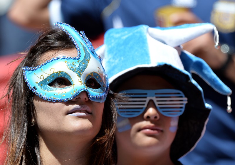 epa04300539 Argentinian supporters before the FIFA World Cup 2014 quarter final match between Argentina and Belgium at the Estadio Nacional in Brasilia, Brazil, 05 July 2014. (RESTRICTIONS APPLY: Editorial Use Only, not used in association with any commercial entity - Images must not be used in any form of alert service or push service of any kind including via mobile alert services, downloads to mobile devices or MMS messaging - Images must appear as still images and must not emulate match action video footage - No alteration is made to, and no text or image is superimposed over, any published image which: (a) intentionally obscures or removes a sponsor identification image; or (b) adds or overlays the commercial identification of any third party which is not officially associated with the FIFA World Cup) EPA/PETER POWELL EDITORIAL USE ONLY