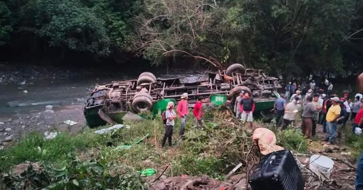 Un autobuz verde este răsturnat cu fața în jos, sunt mulți oameni la fața locului, iar în jur se vede o zonă verde, în statul Veracruz, Mexic, 24 decembrie 2025