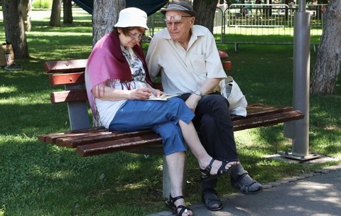Un cuplu de pensionari stă pe o bancă în parc. Foto: Libertatea/ Dumitru Angelescu