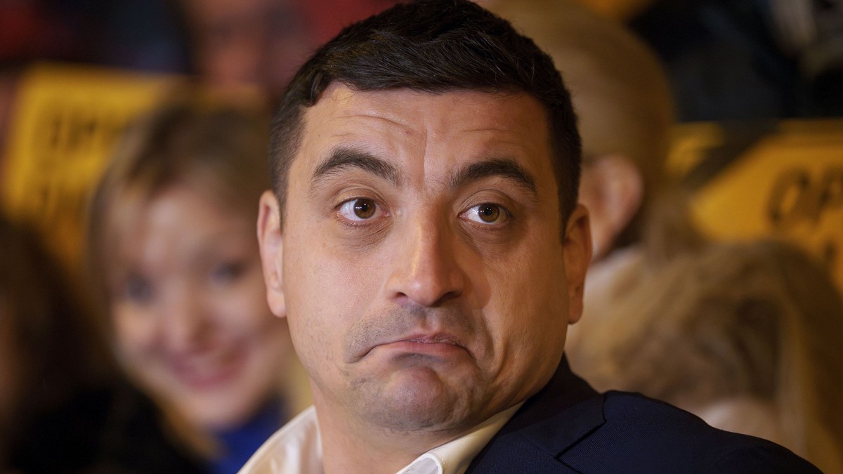 George Simion surprins în cadrul unei conferințe de presă în timp ce se strâmba