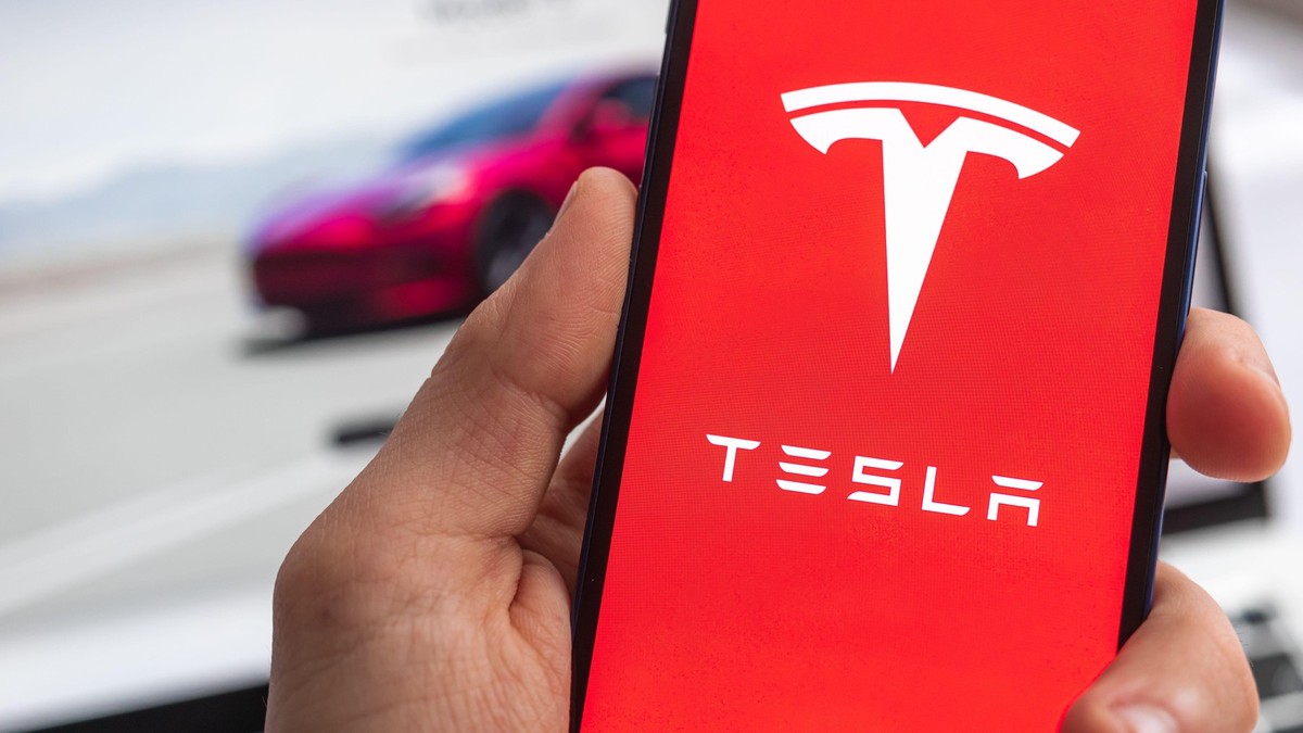 Logo-ul Tesla afișat pe ecranul unui telefon mobil
