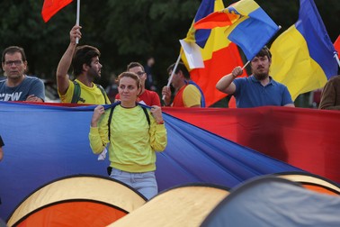 Persoane flutură steaguri tricolore în timpul unui protest organizat de membri și simpatizanți ai Alianței pentru Unirea Românilor (AUR) cerând „revenirea la dreptul de protest”, care „a fost anulat în pandemie”, în septembrie 2020 | Foto: Vlad Chirea