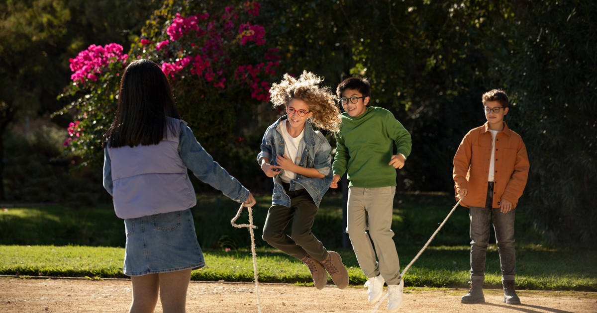 4 copii, 2 baieti si 2 fete sar coarda in parc