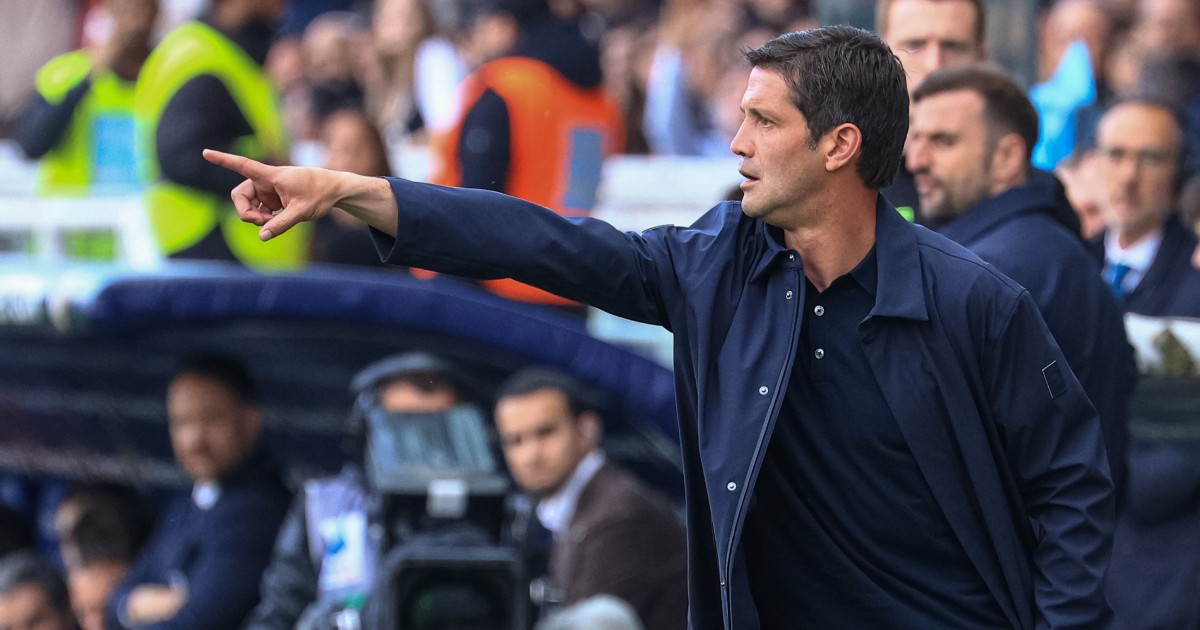 Cristi Chivu, într-o tribună din Parma, Italia, alături de mai mulți suporteri, în timpul unui meci de fotbal. Este îmbrăcat cu o bluză neagră, peste care are o cămașă desfăcută, bleumarin, și arată cu degetul spre teren.
