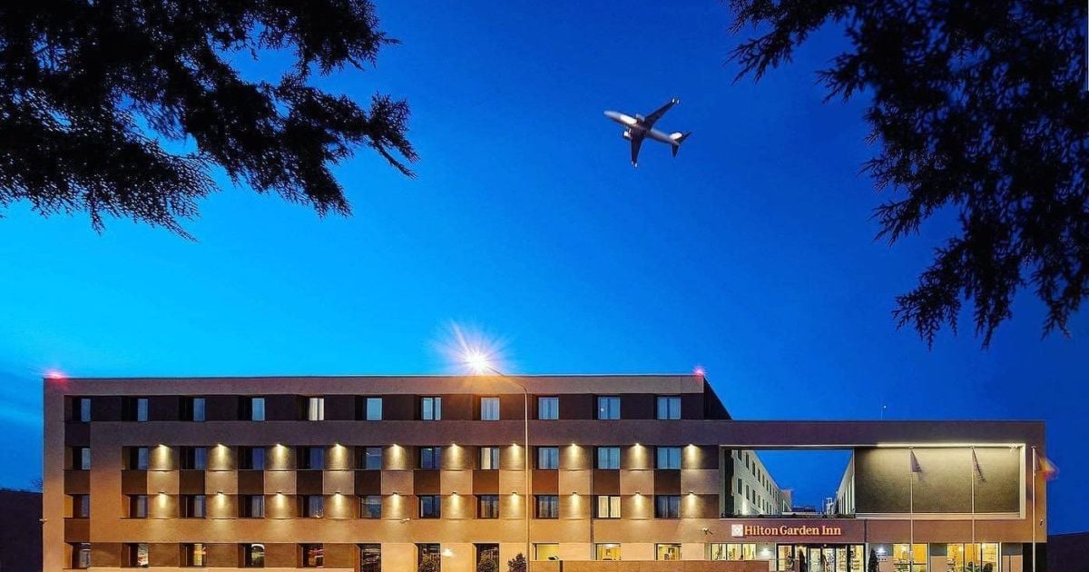 Hotelul Hilton Garden Inn Bucharest Airport, pe deasupra căruia zboară un avion, martie 2024