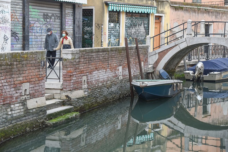 Un cuplu se plimbă pe străzile goale din Veneţia Foto: Hepta