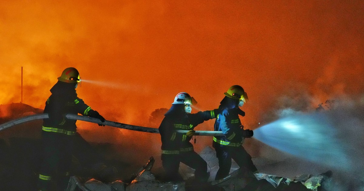 Un grup de pompieri, în timp ce încearcă să stingă un incendiu izbucnit după o explozie