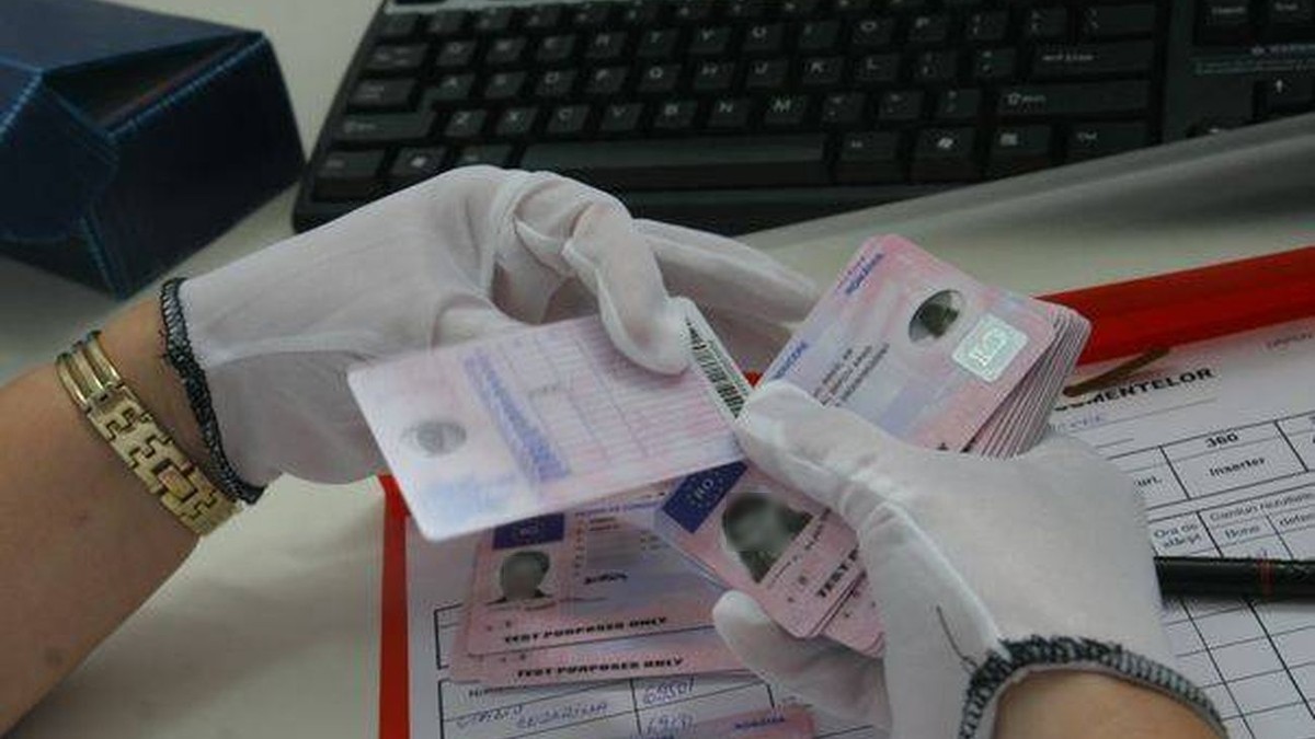 De ce se plătesc permisele auto și certificatele de înmatriculare în conturile RAAPPS. Permise auto ținute de o persoană în mâini, cu mânuși de protecție