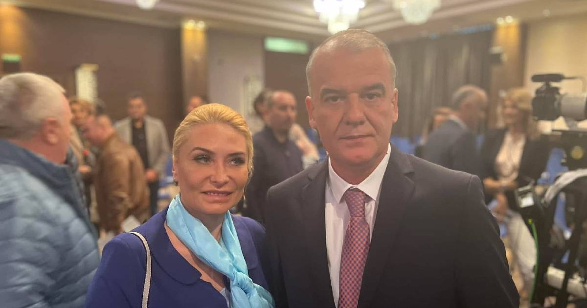 Adriana Georgescu și Ion POpa pozează la un eveniment, pe fundal se văd mai mulți oameni