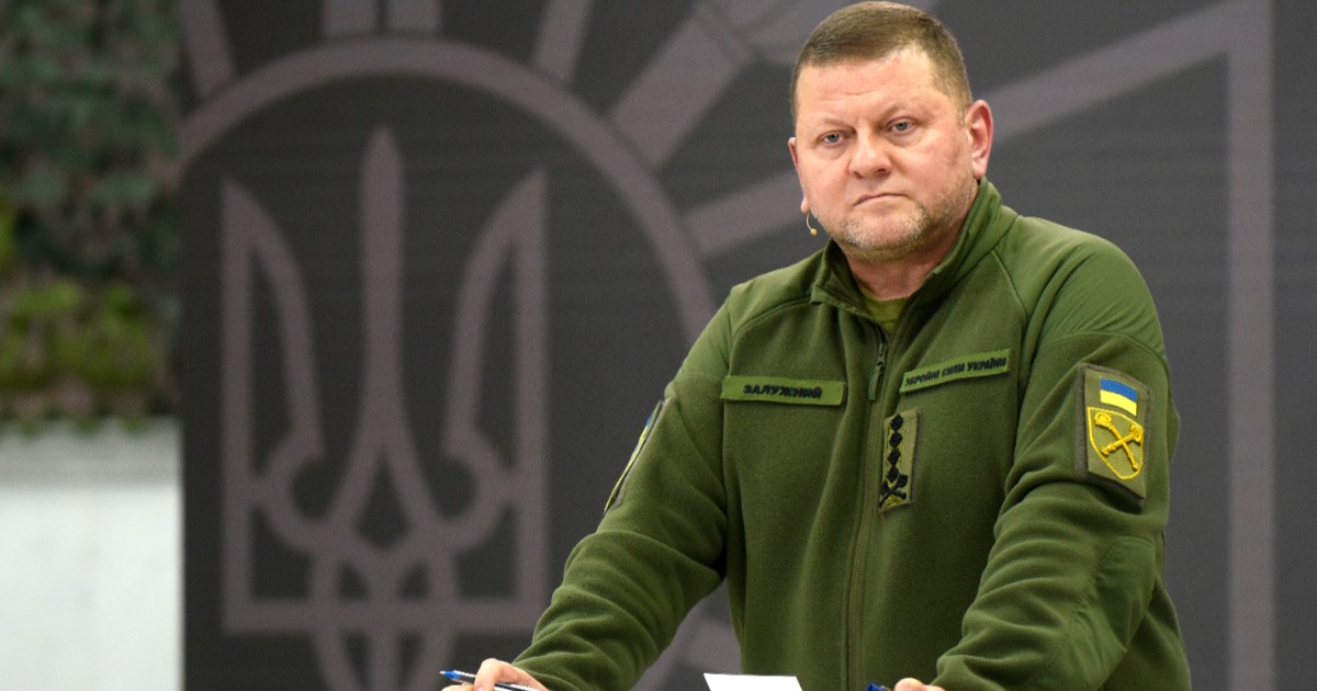 Imaginea îl prezintă pe generalul ucrainean Valeri Zalujnîi îmbrăcat în uniformă militară verde, stând la un pupitru transparent pe un fundal ce afișează stema Ucrainei.