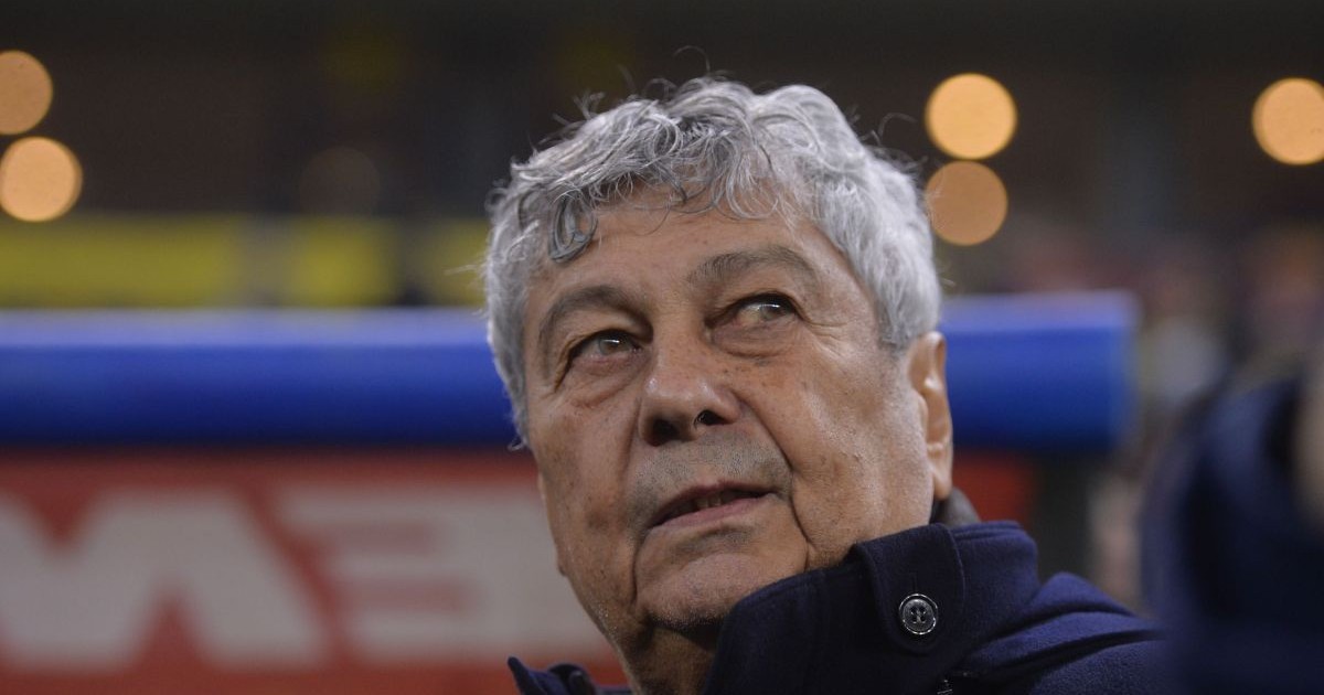 Mircea Lucescu, pe stadion, privind ușor în sus, îmbrăcat într-o geacă de iarnă cu gulerul ridicat