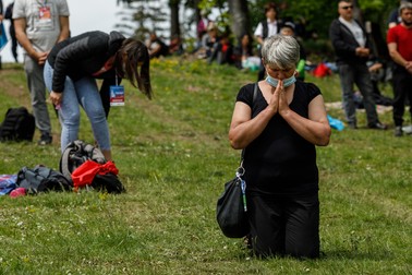 O femeie se roagă în genunchi în timpul slujbei