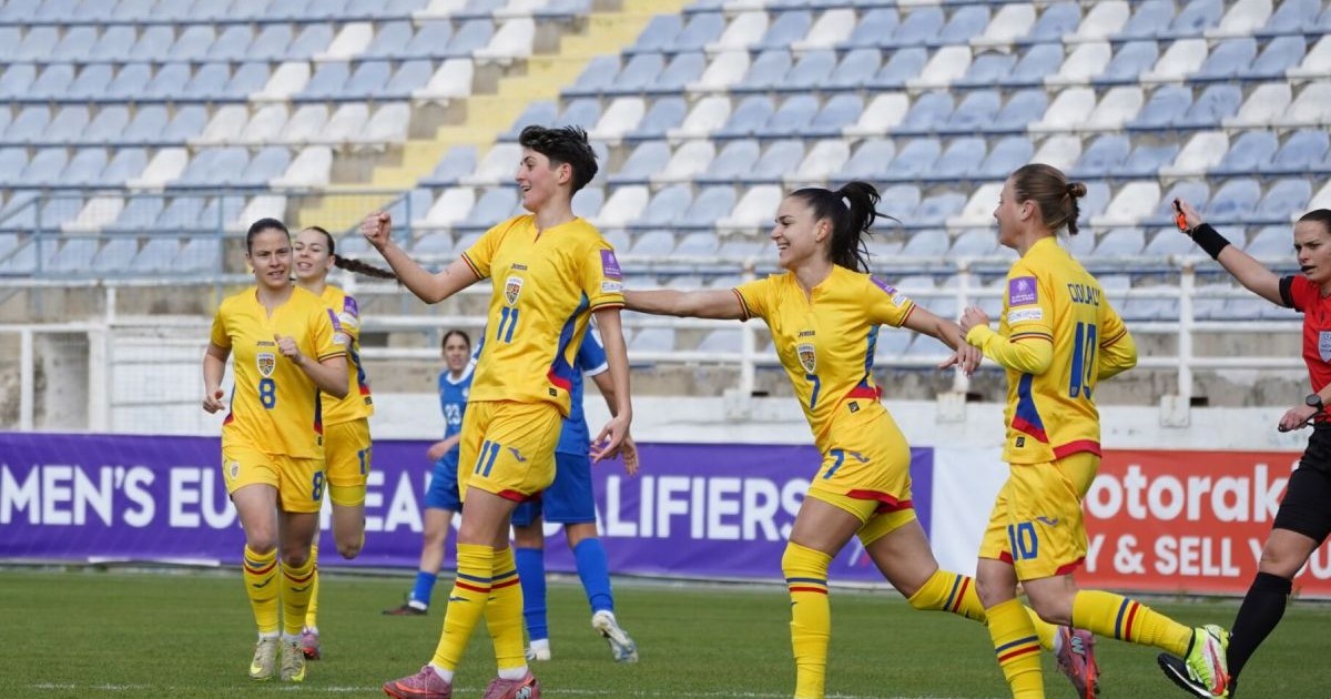 Fotbaliste din echipa națională de fotbal feminin a României, în timp ce se bucură pe teren după un gol, cu tribune pe fundal