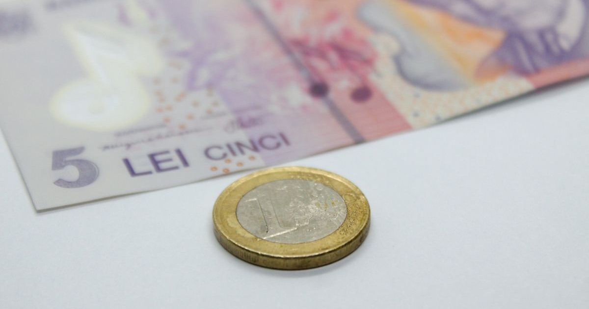 O bancnotă românească de 5 lei și o monedă de un euro