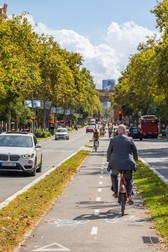 Barcelona, Spania - 20 septembrie 2021: pistă de biciclete pe bulevardul Sant Joan. Peisaj urban cu bicicliști pe banda din mijloc. Turiștii și localnicii folosesc bicicleta ca mijloc rapid de transport prin orașul aglomerat. Foto: Shutterstock