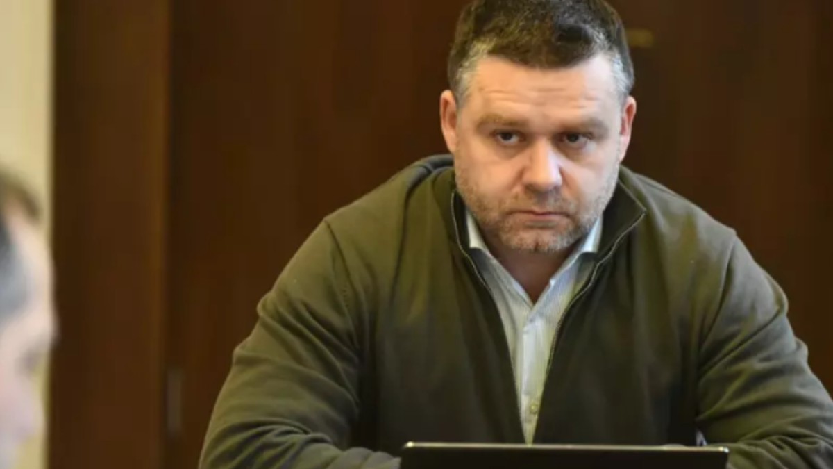 Ciprian Ciucu în timp ce stă la birou și privește spre un om.