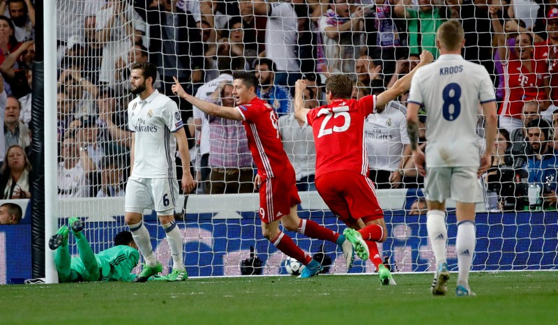epa05914068 Bayern Munich's Polish striker Robert Lewandowski (C) and Thomas Muller (2R) celebrate the own goal by Sergio Ramos (not in the picture) of Real Madrid during the Champions League quarter finals second leg soccer match between Real Madrid and Bayern Munich played at Santiago Bernabeu's stadium in Madrid, Spain on 18 April 2017. EPA/JUANJO MARTIN