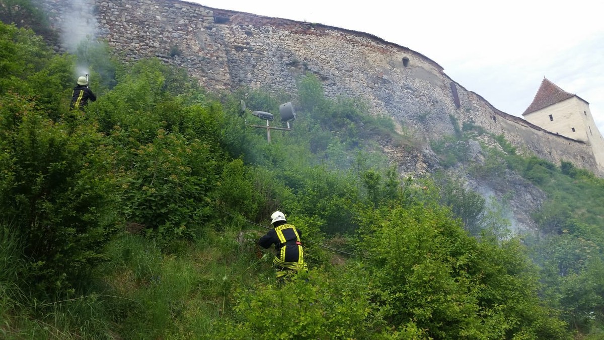 Incendiu de vegetaţie uscată lângă zidurile Cetății Râşnov. Pompierii au stins focul după o oră