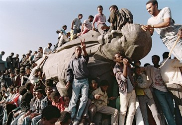 Tineri din Etiopia sărbătoresc lângă statuia dărâmată a lui Lenin din Addis Ababa, capitala Etiopiei, pe 23 mai 1991, la două zile după înfrângerea guvernului pro-comunist. Foto: Profimedia