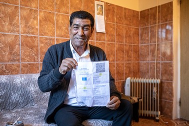 Caliu arătând zâmbitor certificatul de vaccinare