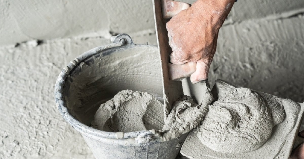 Care este diferenţa dintre ciment, beton şi mortar - Imagine cu un zidar care ia mortar dintr-o găleată
