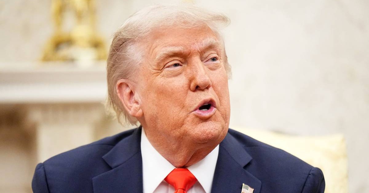 Președintele american Donald Trump în Biroul Oval, vorbește și are gura deschisă, poartă un costum albastru și o cravată roșie.