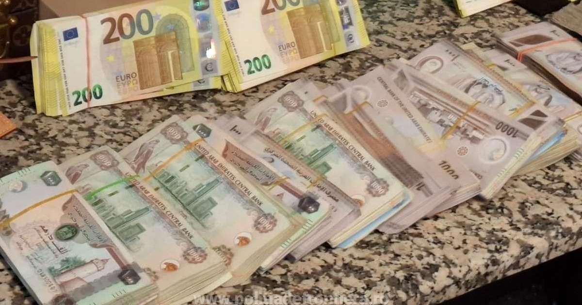 Teancuri de bancnote de dirham și euro, așezate unul lângă altul, pe o masă, la aeroportul Otopeni din București