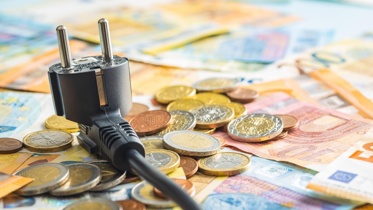 Ideea de scumpiri, bani imp[;tia'i pe o masă alături de un intrerupător electric