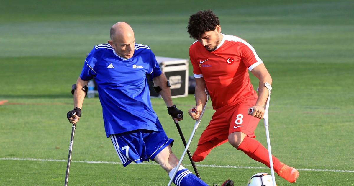 Un fotbalist al echipei Turciei (în roșu) driblează un adversar din formația Germaniei, în timpul unui meci de la Campionatul European al Invalizilor. (FOTO: HEPTA)