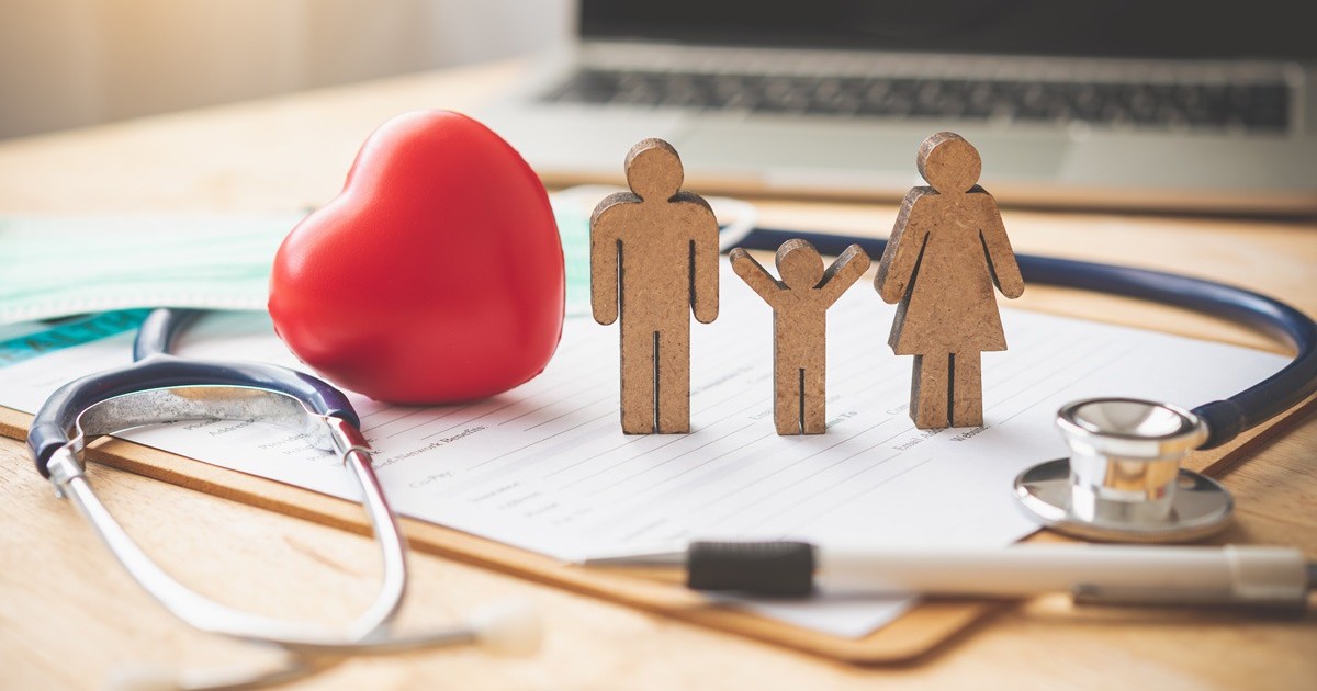 Pe o masa sta un formular, un stetoscop, o inima rosie si o familie confectionata din lemn si un piv. Asigurari de sanatate, privatizare, CNAS. ministrul Sanatatii despre asigurari. Foto Envato