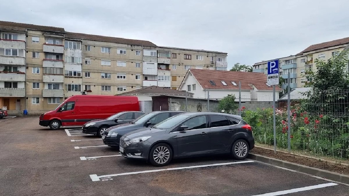 Patru mașini parcate într-o parcare de domiciliu din Oradea, în spate se văd blocurile