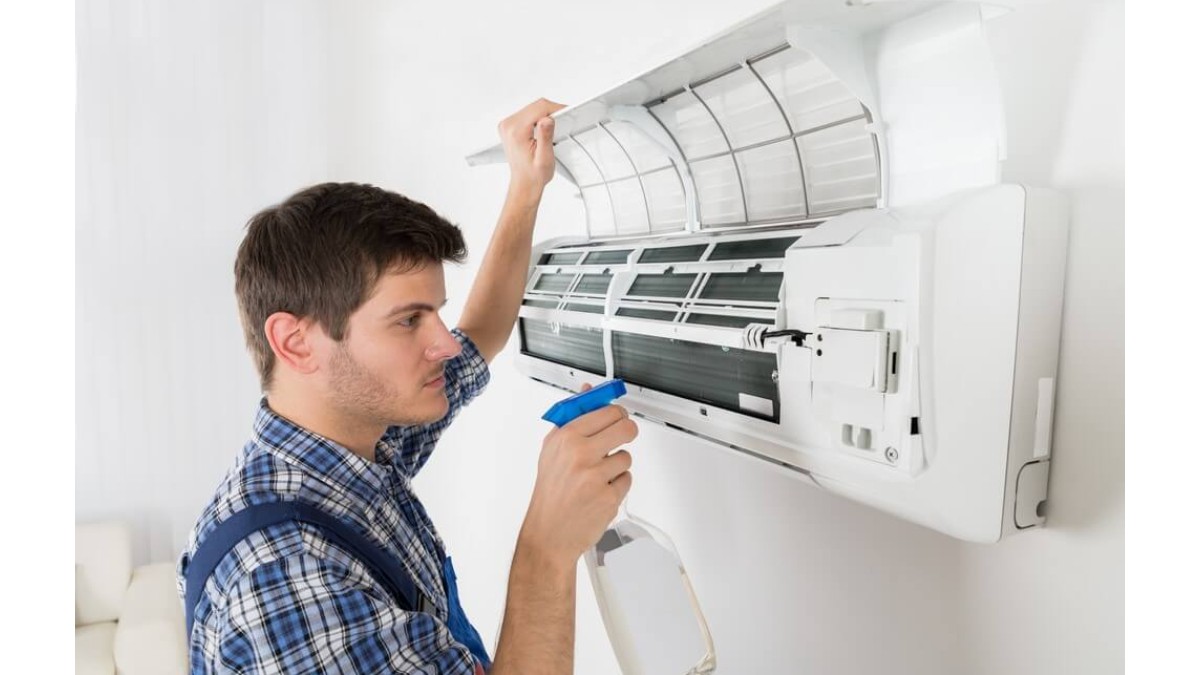 Barbat tanar care curata un aer conditionat