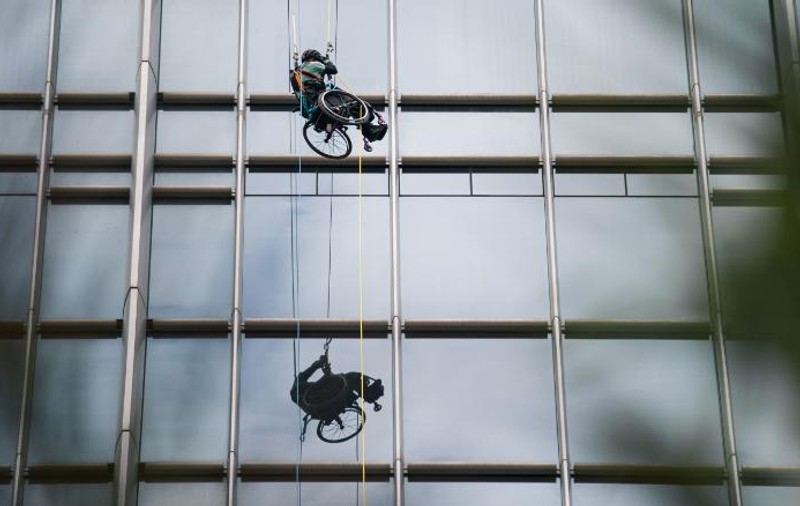 A escaladat un zgârie-nori în scaunul cu rotile. Imagini spectaculoase cu un sportiv paralizat din Hong Kong