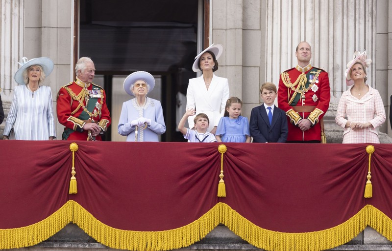 Membrii Familiei Regale urmărind reprezentația Aviației Britanice, deasupra Palatului Buckingham. Regina Elisabeta, alături de prințul Charles, soția sa< Camilla, ducesa de Cornwall, prințul William și soția sa, Kate, cu cei trei copii ai cuplului regal | Foto: Hepta