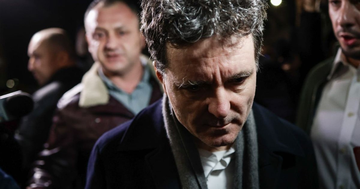 Nicușor Dan, îmbrăcat într-un palton negru cu un fular gri în jurul gâtului, înconjurat de jurnaliști, în întuneric, în fața Palatului Cotroceni, 6 martie 2026