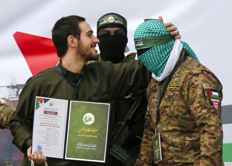 DEIR AL BALAH, GAZA - FEBRUARY 22: Israeli hostage Eliyah Cohen kisses the forehead of a member of the Al-Qassam Brigades, the military wing of Hamas, as Al-Qassam Brigades hand over on Saturday Israeli hostages Omer Shem-Tov, Eliya Cohen and Omer Wenkert to the International Committee of the Red Cross (ICRC) as part of the seventh exchange under the Jan. 19 ceasefire deal in Nuseirat Refugee Camp of the Deir al-Balah, Gaza on February 22, 2025. Ashraf Amra / Anadolu/ABACAPRESS.COM
