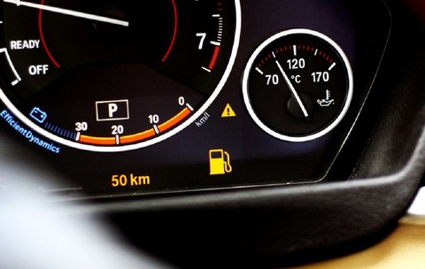 Martorul de combustibil aprins pe bordul unei mașini, indicând o autonomie rămasă de 50 km.