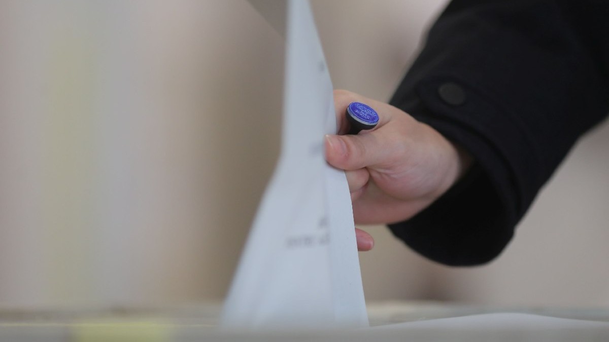 O persoană introduce un buletin de vot într-o urnă, la alegerile parlamentare, în Timișoara, duminică, 1 decembrie 2024.